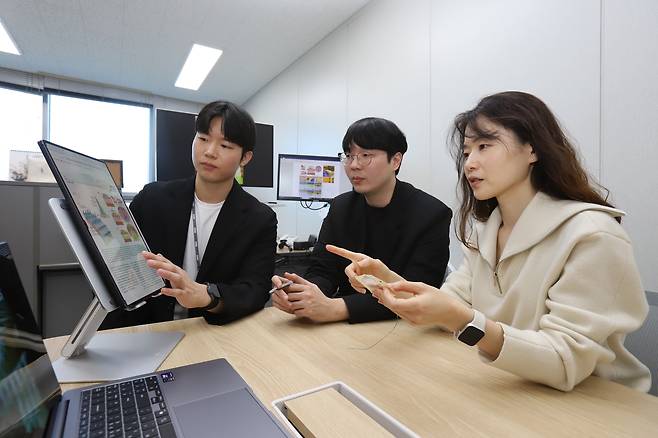 전소희(오른쪽) 한국기계연구원 책임연구원이 마이크로 니들 샘플을 보며 연구팀과 논의하고 있다.[한국기계연구원 제공]
