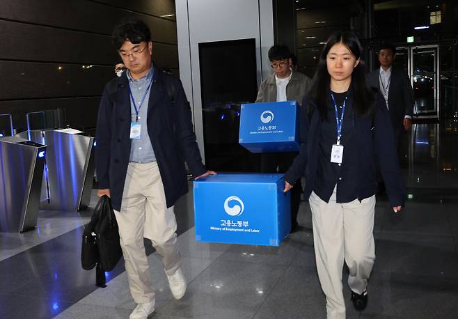 경기남부경찰청 신안산선 공사장 붕괴 사고 수사전담팀 수사관들과 고용노동부 근로감독관들이 25일 경기도 광명시 신안산선 지하터널 공사장 붕괴 사고와 관련 시공사인 포스코이앤씨 인천 본사(인천 연수구)에서 압수수색을 마친 뒤 압수품을 옮기고 있다. [연합]