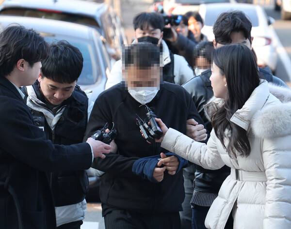 울산경찰청으로 연행되는 캄보디아 '로맨스&nbsp;스캠' 부부. 연합뉴스