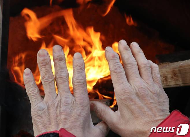 대전 유성구 노은농수산물도매시장에서 상인이 모닥불로 추위를 녹이고 있다. /뉴스1 ⓒ News1 김기태 기자