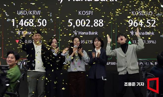 코스피가 장 중 '5000'을 돌파한 22일 서울 중구 하나은행 딜링룸에서 직원들이 기뻐하며 박수를 치고 있다.