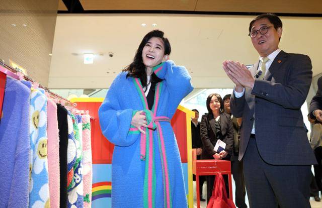 최휘영(오른쪽) 문화체육관광부 장관과 함께 22일 서울 영등포구 더현대 서울에서 열린 '2026 코리아그랜드세일' 행사장을 찾은 이부진 한국방문의해위원회 위원장이 세일 참여 브랜드 중 하나인 위글위글에서 로브 제품을 입어보고 있다. 문체부 제공