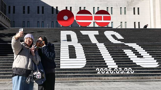 People take photos in front of a promotional installation for boy band BTS's comeback in front of the Sejong Arts Center in Jongno District, central Seoul, on Jan. 22. [YONHAP]