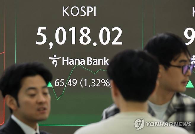 23일 서울 중구 하나은행 본점에서 직원들이 증시와 환율을 모니터하고 있다. 이날 코스피는 상승 출발해 장 초반 5000포인트를 넘어서는 등 상승·하락을 반복하고 있다. [연합뉴스]