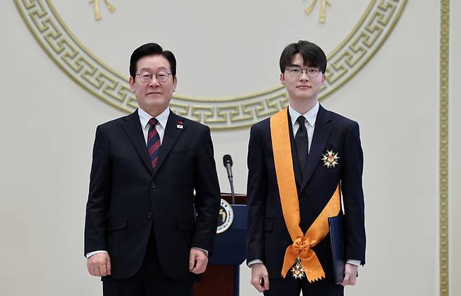 이재명 대통령이 지난 2일 청와대 영빈관에서 열린 신년 인사회에서 프로게이머 ‘페이커’ 이상혁 선수에게 체육훈장 청룡장을 수여한 뒤 기념촬영하고 있다. [연합뉴스]