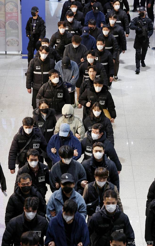 [인천공항=뉴시스] 김진아 기자 = 한국 국적 캄보디아 스캠조직 피의자들이 23일 오전 인천국제공항 제2터미널을 통해 강제 송환되고 있다.    초국가범죄 특별대응 TF는 캄보디아를 거점으로 우리 국민 869명에게 약 486억원을 편취한 한국 국적 피의자 73명을 강제 송환했다. 2026.01.23. bluesoda@newsis.com /사진=김진아