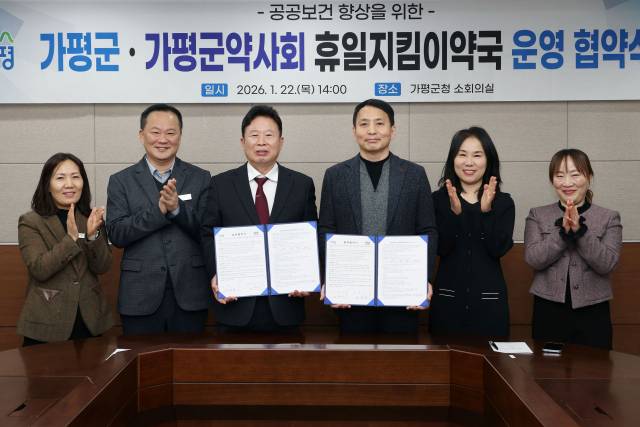 ▲서태원 가평군수(사진 왼쪽에서 세번째)와 안병현 가평군약사회 회장(사진 왼쪽에서 네번째) 등이 휴일지킴이약국 운영 협약식 후 협약서를 보이며 기념촬영을 하고 있다.ⓒ가평군