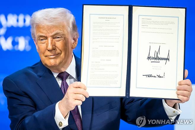 평화위원회 헌장 들고 있는 트럼프 대통령 [AP 연합뉴스. 재판매 및 DB 금지]