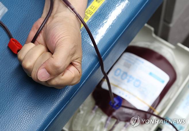 '헌혈을 위해' 세계 헌혈자의 날을 하루 앞둔 2025년 6월 13일 서울 종로구 광화문광장에 마련된 헌혈버스에서 한 시민이 헌혈하고 있다.[연합뉴스 자료사진]