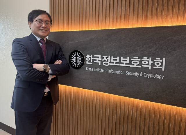김호원 한국정보보호학회장이 학회 CI를 배경으로 포즈를 취했다. 학회는 서울 역삼역 인근에 있다.