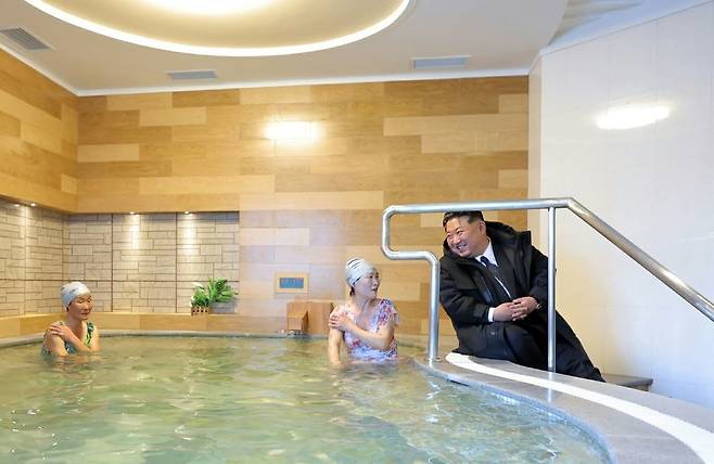 21일 새로 건설된 온포근로자휴양소를 찾은 김정은이 여성탕에 들어가 나이든 여성들과 대화하며 활짝 웃고 있다. 노동신문 뉴스1