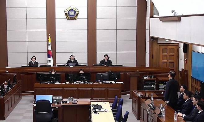 12·3 내란 중요임무 종사 혐의를 받는 한덕수 전 국무총리(오른쪽 피고석에 선 사람)가 2026년 1월21일 서울중앙지법에서 열린 1심 선고 공판에 출석해 있다. 서울중앙지법 제공, 연합뉴스