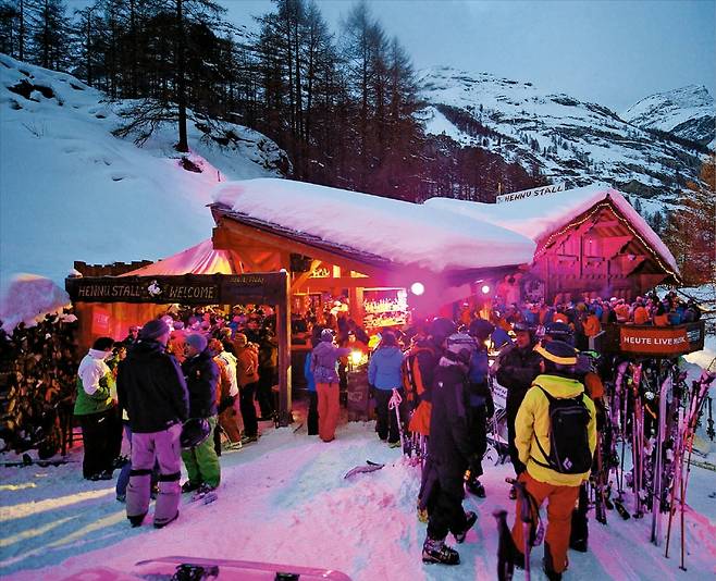 스위스 체르마트 지역의 유명 아프레 스키 바인 ‘헤누 슈탈’(Hennu stall) 앞에서 스키어들이 휴식을 즐기고 있다.  체르마트 관광청 홈페이지
