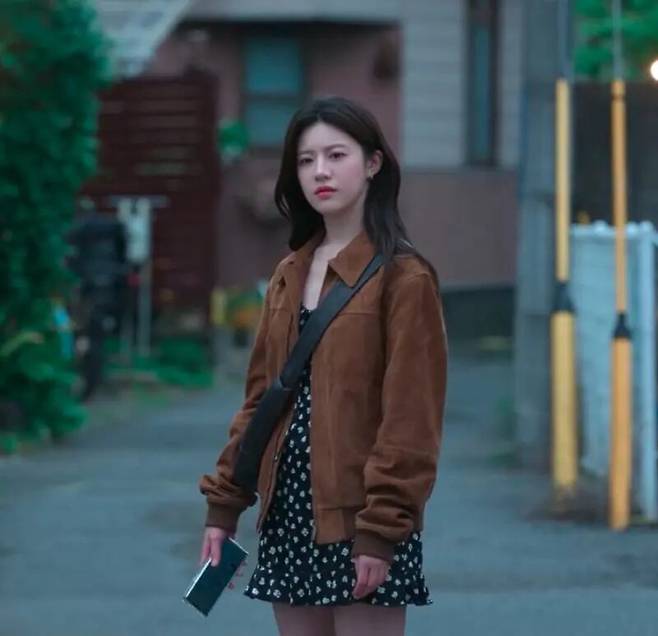 오라리(Auralee)의 스웨이드 보머 재킷, 애버크롬비 앤 피치(Abercrombie & Fitch)의 폴카 도트 드레스, 르메르의 크로와상 백. 넷플릭스.