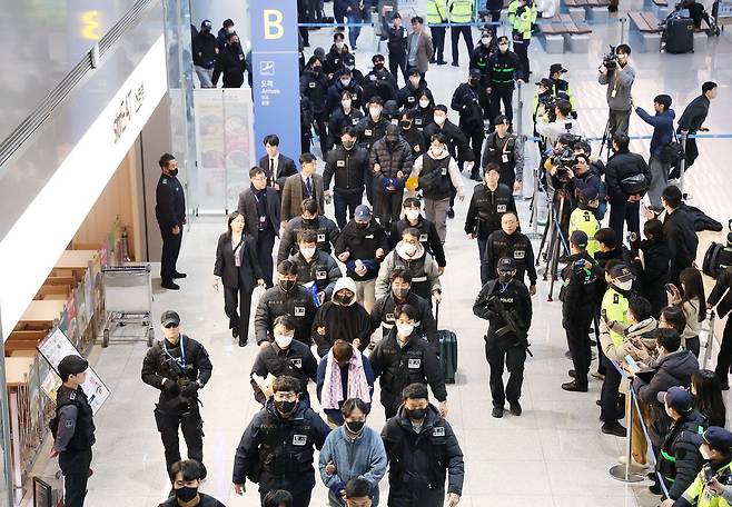 캄보디아에서 스캠(scam·사기), 인질강도 등 범행을 저지른 한국인 범죄 조직원들이 23일 인천국제공항을 통해 국내로 송환돼 수사기관으로 압송되고 있다. 연합뉴스