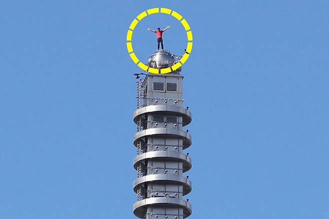 25일(현지시간) 미국의 암벽 등반가 알렉스 호놀드가 대만 타이베이의 초고층 빌딩 타이베이 101을 안전장비 없이 등반해 건물 꼭대기에 서 있다. AP=연합뉴스