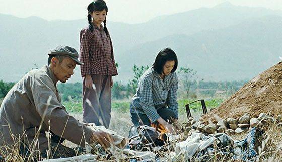 영화 ‘인생’의 한 장면. 여우칭 무덤 앞의 푸구이, 펑샤, 쟈전(왼쪽부터). [사진 성민엽]