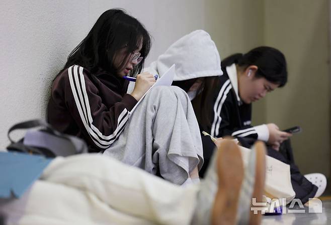 [서울=뉴시스] 홍효식 기자 = 18일 서울 강남구 코엑스에서 열린 2026학년도 정시 대학입학정보박람회를 찾은 입시생들이 자료를 살펴보고 있다. 사진은 기사 내용과 무관. 2025.12.18. yesphoto@newsis.com