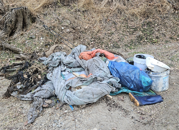 외국인 남성이 땅에서 꺼낸 쓰레기. 연합뉴스