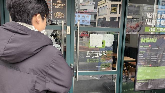 26일 서울 마포구 프랭크버거 신촌서강대점 입구 앞에 '진격의거인' 콜라보 굿즈가 모두 품절됐다는 안내문이 붙어있다. /사진=장현우 수습기자
