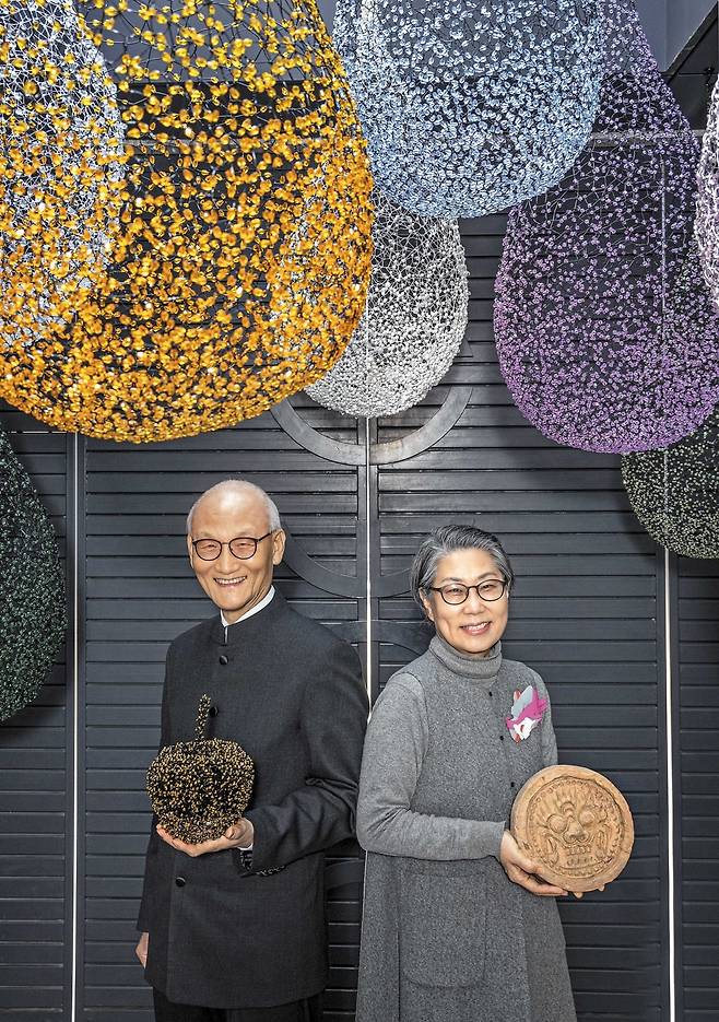 지난 2022년 본지 인터뷰 때 만난 ‘기와 검사’ 유창종(왼쪽)과 금기숙 작가. 서울 부암동 유금와당박물관 정문 앞에서 활짝 웃고 있다. 남편은 아내의 작품을, 아내는 와당 수집품을 들었다. 천장에 매달린 설치물은 금 작가의 작품이다. /이신영 영상미디어 기자