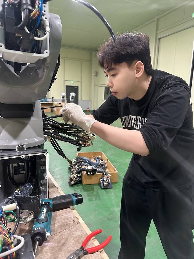 이달 7일 한국폴리텍다솜고 컴퓨터기계과를 졸업하고 산업용 로봇 제작 기업에 입사한 베트남 출신 동응옥두안 씨가 로봇 내부 연결선을 살피고 있다. 충북 제천에 있는 한국폴리텍다솜고는 다문화 청소년을 위한 기술계 기숙형 대안학교다. 2012년 개교했으며 매년 45명 안팎의 현장형 기능인재를 양성하고 있다.한국폴리텍대 제공
