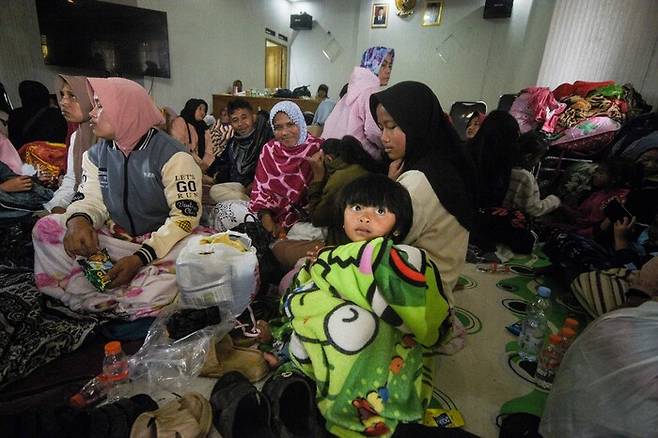 지난 24일 인도네시아 서자바주 반둥 바시르랑구(Pasirlangu) 마을에서 산사태가 발생한 후 주민들이 마을 사무소에 마련된 대피소에서 몸을 피하고 있다. AFP 연합뉴스