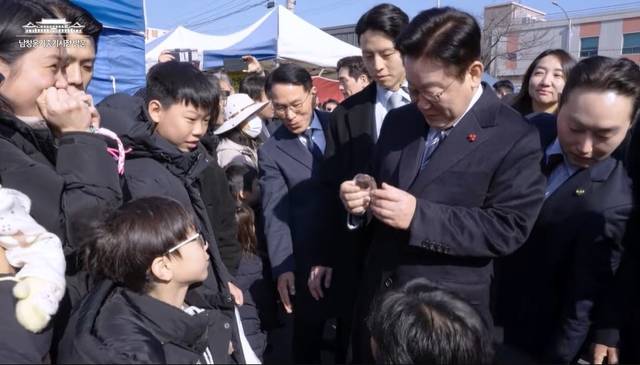 어린아이에게 두바이쫀득쿠키를 선물받은 이재명 대통령. 이재명 대통령 유튜브 갈무리