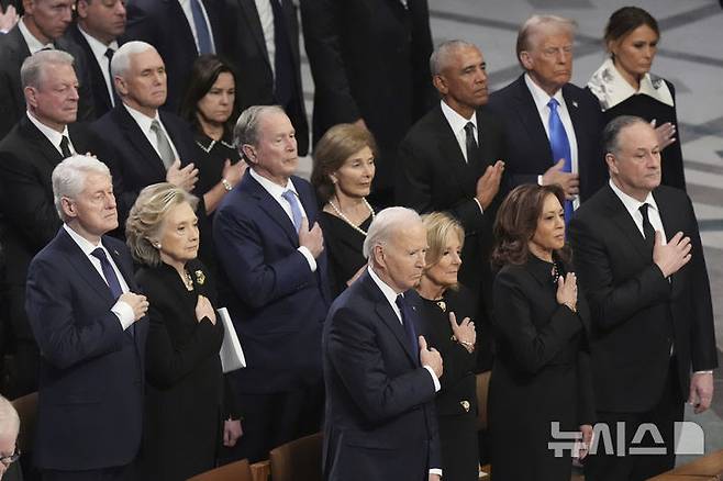 [워싱턴=AP/뉴시스]지난해 1월 9일(현지시각) 워싱턴 DC 국립 대성당에서 엄수된 지미 카터 전 대통령의 국가장례식에 조 바이든 대통령, 도널드 트럼프 대통령 당선인, 빌 클린턴 전 대통령, 버락 오바마 전 대통령 등이 참석해 국기에 경례하고 있다. 2025.01.10.