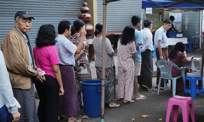 25일(현지시간) 미얀마 양곤에서 총선 3차 투표에 참가하기 위한 시민들이 투표소 앞에 줄을 서 있다. AP연합뉴스