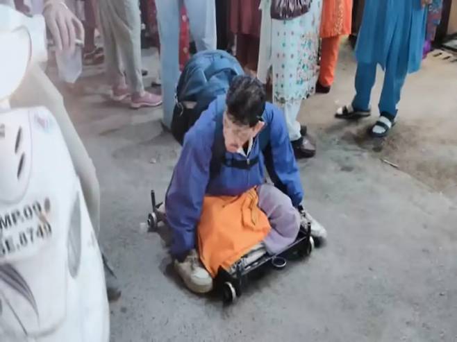 인도 마디아프라데시주 인도르의 사라파 시장 인근에서 망길랄이 바퀴가 달린 판 위에 앉아 구걸하던 모습. 그는 말을 걸지 않는 방식으로 동정심을 유도해 왔다. 현지 영상 캡처