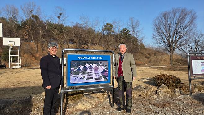 김성수(오른쪽) 주교가 강화 우리마을의 발달장애인 양로원 조감도 앞에서 촬영했다. 김 주교 뒤로 보이는 땅이 양로원이 들어설 자리. 조감도 왼쪽은 우리마을 원장 최수재 신부. /김한수 기자