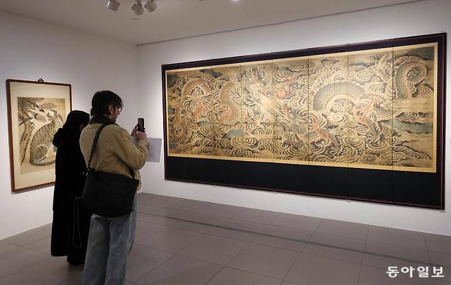 20일 서울 종로구 삼청동 갤러리현대에서 민중의 삶과 해학을 담은 민화와 권위와 형식의 미학이 돋보이는 궁중 회화를 함께 선보이는 기획전을 관람객들이 감상하고 있다. 전영한 기자 scoopjyh@donga.com