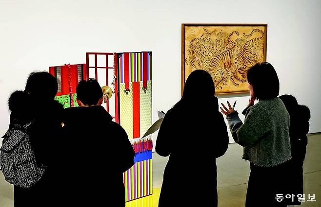 20일 서울 종로구 삼청동 갤러리현대에서 민중의 삶과 해학을 담은 민화와 권위와 형식의 미학이 돋보이는 궁중 회화를 함께 선보이는 기획전을 관람객들이 감상하고 있다. 전영한 기자 scoopjyh@donga.com