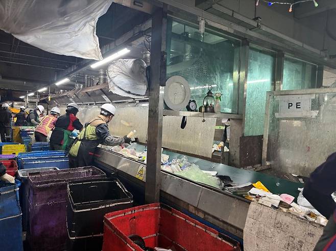강남환경자원센터에서 분류 작업자들이 컨베이어벨트를 따라 선별작업을 하고 있다. 사진=이창훈 기자