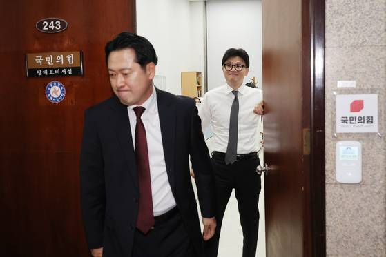 2024년 12월 한동훈 당시 국민의힘 대표가 당 대표실에서 장동혁 의원이 나가는 사이 미소를 짓고 있다. [연합뉴스]