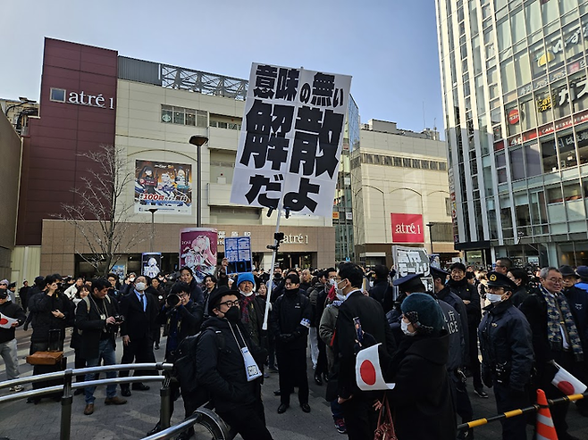 27일 도쿄 지요다구 아키하바라역에서 진행된 일본 중의원 선거유세에서 한 시민이 중의원 해산을 비난하는 팻말을 들고 있다. [도쿄 이승훈 특파원]
