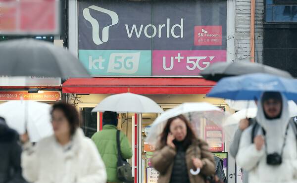 2025년 12월 23일 오후 서울의 한 휴대폰 매장 앞으로 시민이 지나가고 있다. / 뉴스1
