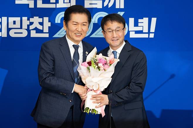 정청래 더불어민주당 대표와 한병도 신임 원내대표가 지난 12일 서울 여의도 국회에서 열린 최고위원회의에 앞서 꽃다발을 들고 기념 촬영을 하고 있다. /뉴스1