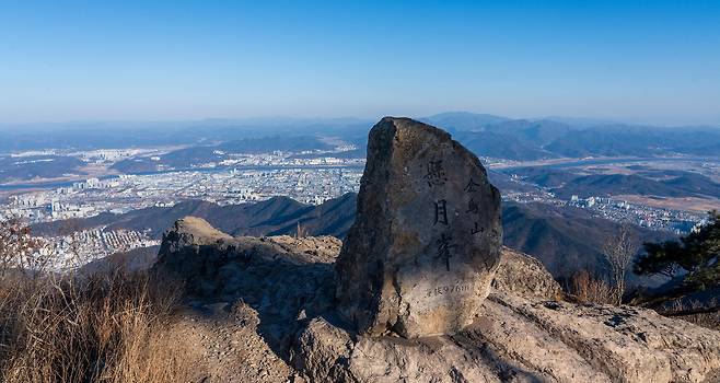 금오산 현월봉. 정상석 너머로 구미 산업단지가 보인다. 현월봉 아래의 벼랑 한편에 약사암이 있다. 백종현 기자