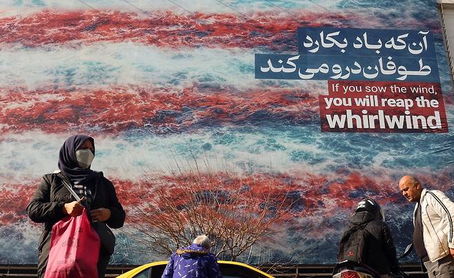 27일(현지시간) 이란 테헤란에 걸린 대형 반미(反美) 광고판 앞을 시민들이 지나가고 있다. EPA연합뉴스