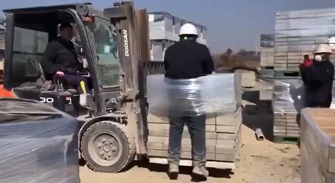 A migrant worker is seen tied with plastic wrapping to a forklift at a brick factory in Naju, South Jeolla, on Feb. 26, 2025, in this screenshot from a video obtained by a migrant worker network in Gwangju. [YONHAP]