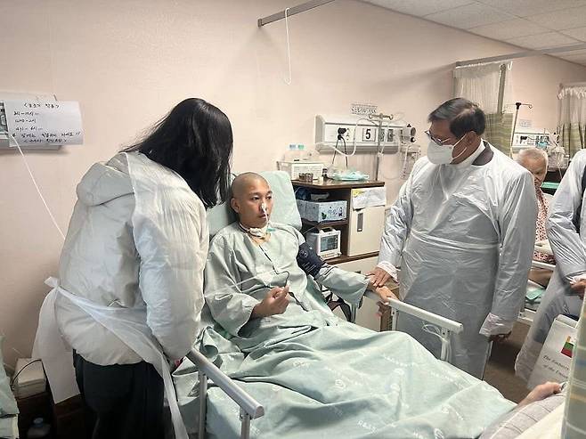 A Myanmar migrant worker who suffered an electric shock accident at the Seoul Expressway construction site in Gwangmyeong, Gyeonggi in August 2025 lies in bed (center). [KOREA MYANMAR SOLIDARITY]