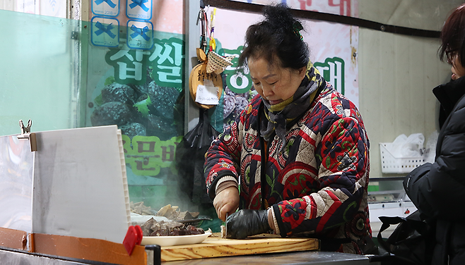 신희선 사장이 순대를 썰고 있다. 가게 한 켠에는 블루리본 스티커 4개가 붙어있다. ⓒ제주의소리