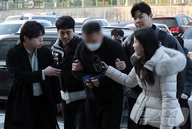 캄보디아에서 연애를 빙자한 사기 일명  '로맨스스캠'으로 120억원을 가로챈 한국인 총책 부부가 23일 국내로 강제 송환돼 울산경찰청 반부패수사대로 연행되고 있다. 2026.1.23/뉴스1 ⓒ News1 김세은 기자