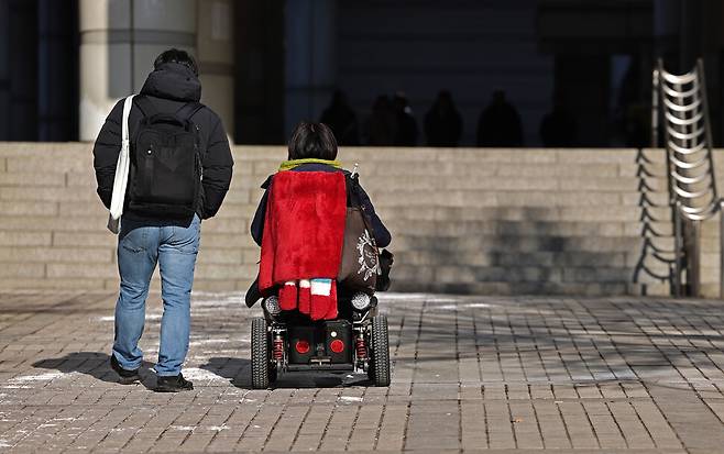 장애인 활동가 문애린(오른쪽)씨가 2026년 1월29일 서울 서초구 서울중앙지방법원에서 열린 선고공판에 출석하고 있다.