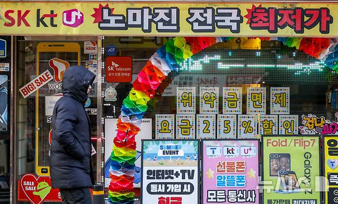[서울=뉴시스] 정병혁 기자 = 4일 서울시내 휴대폰판매점 앞에서 시민들이 이동하고 있다. KT의 번호이동 이탈이 위약금 면제 시행 이후 빠르게 확대되며 사흘간 누적 5만명을 넘어섰다. 이탈 고객의 이동은 SK텔레콤에 가장 많이 집중된 것으로 나타났다. 이동통신업계에 따르면 KT가 위약금 면제를 시작한 지난해 12월 31일부터 이달 3일까지 KT와 기존 계약을 해지한 가입자는 누적 5만2661명으로 집계됐다. 2026.12.04. jhope@newsis.com
