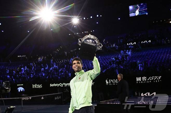카를로스 알카라스(스페인)가 1일 호주 멜버른에서 열린 호주오픈 테니스 대회 남자 단식 결승에서 우승컵인 노먼 브룩스 챌린지컵을 들어 보이고 있다. ⓒ AFP=뉴스1