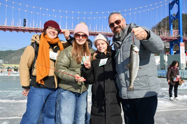 ▲ 2026 화천산천어축제 폐막일인 1일, 축제장을 방문한 외국인 단체 관광객, 자유 여행가들이 산천어 얼음낚시 재미에 흠뻑 빠져 있다.