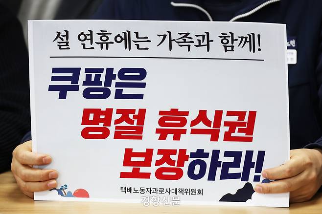 택배노동자 과로사 대책위원회 소속 활동가가 8일 서울 중구 민주노총에서 열린 쿠팡 택배노동자 설 연휴 휴식권 보장 촉구 기자회견에서 손팻말을 들고 있다. 한수빈 기자
